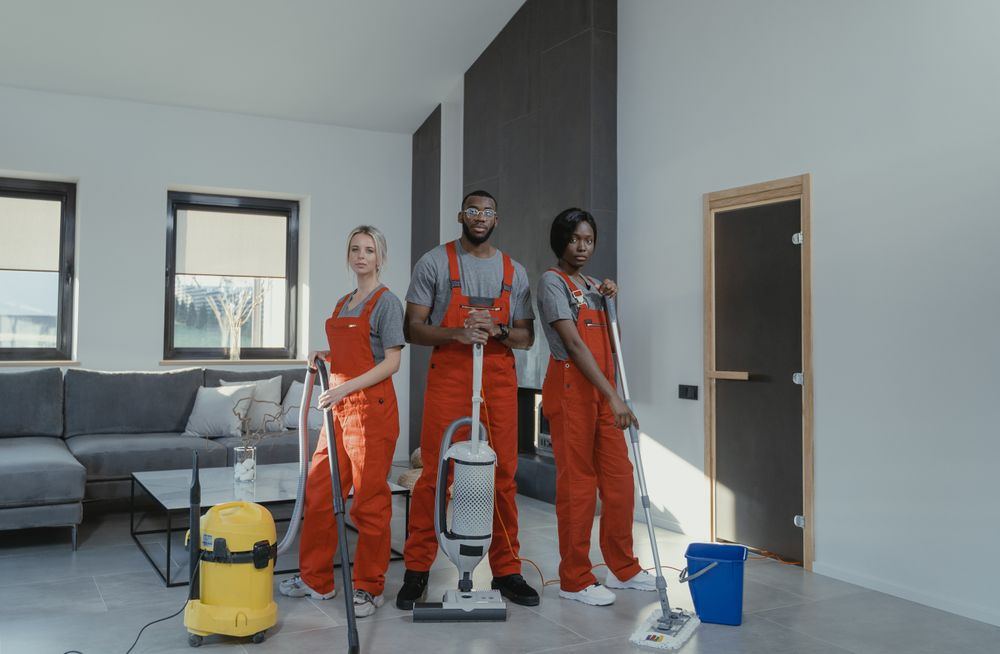 Professional cleaning team with equipment standing in a bright Oklahoma home