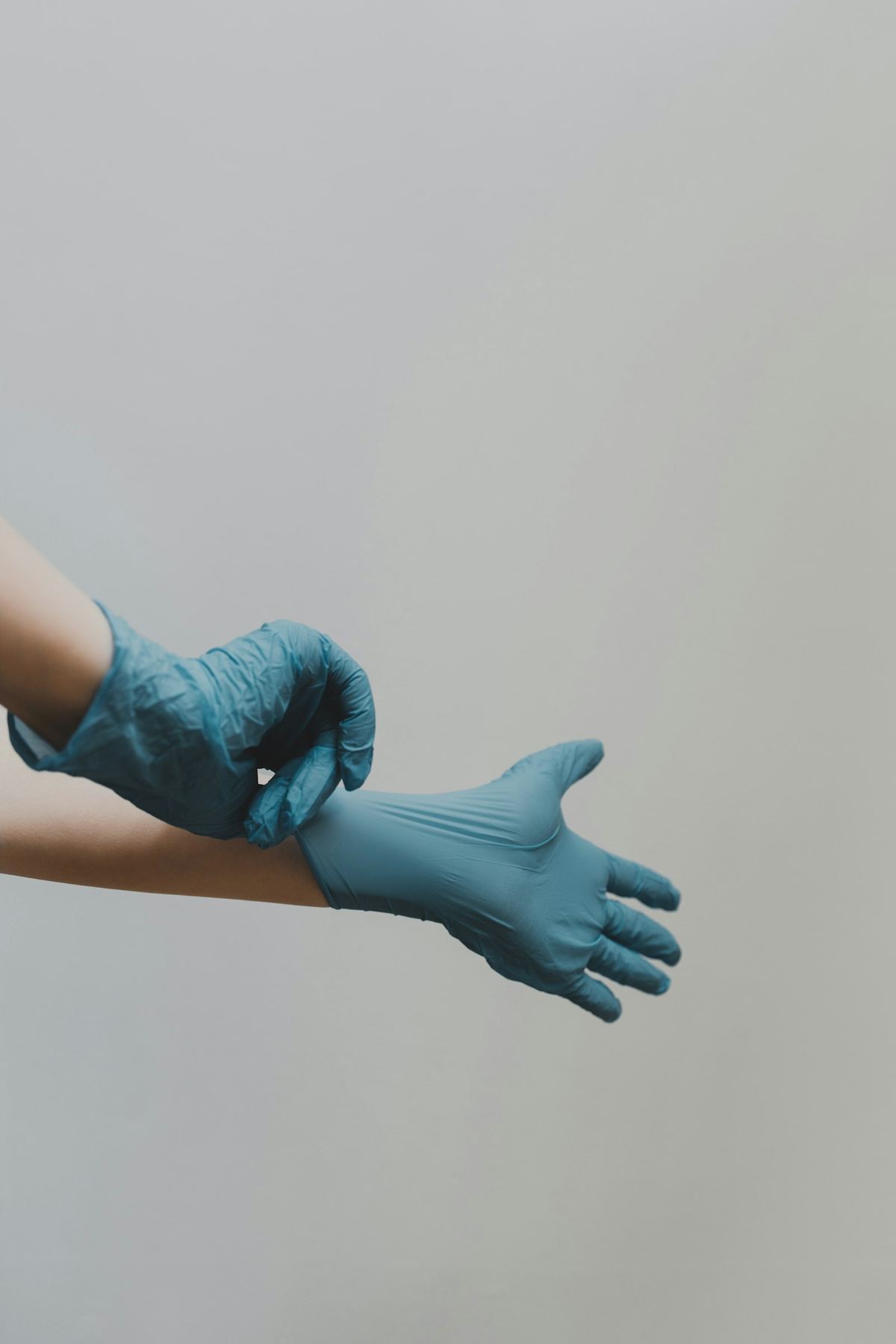 Technician putting on protective nitrile gloves before biohazard decontamination work