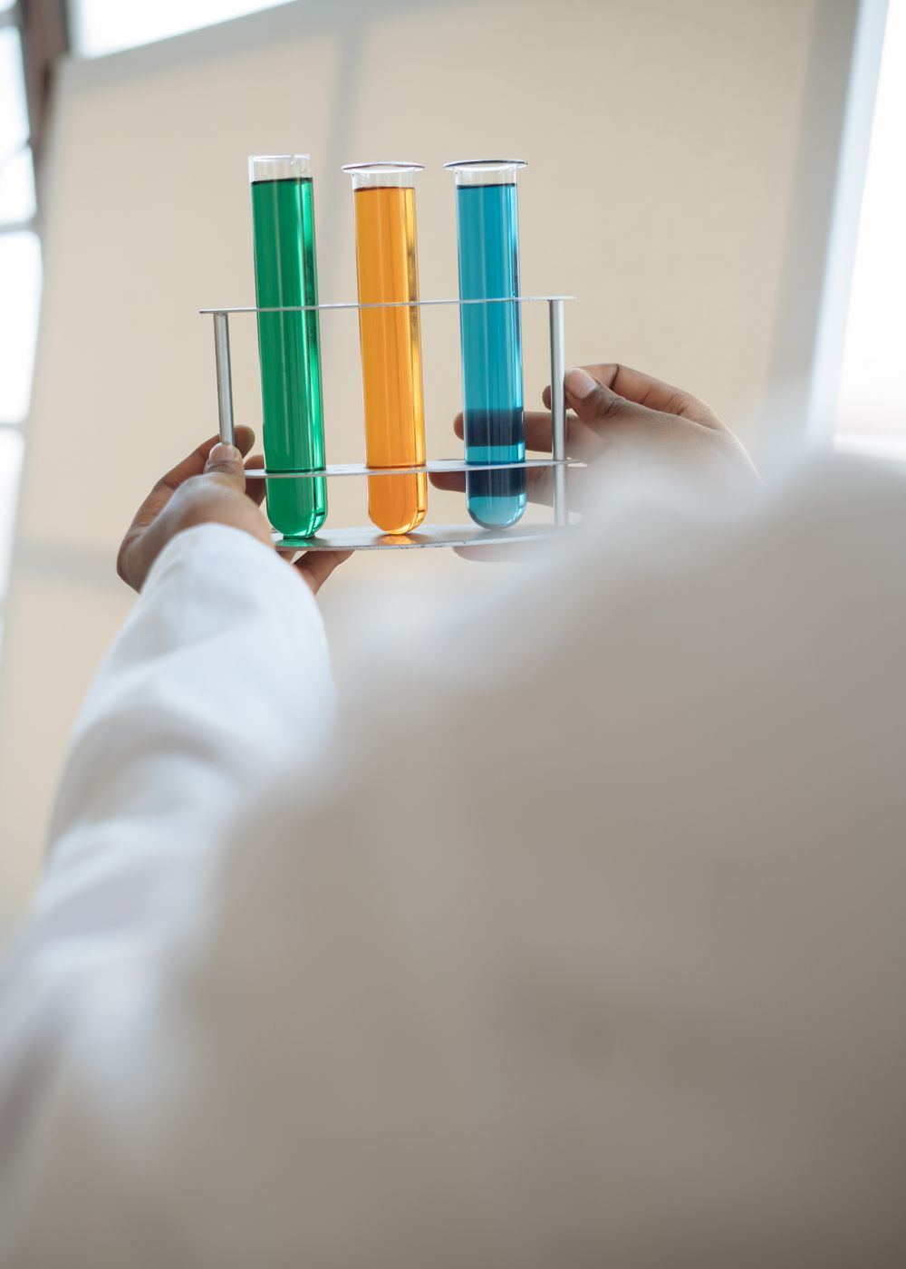 Scientist holding a rack of test tubes during contamination testing in an Oklahoma laboratory