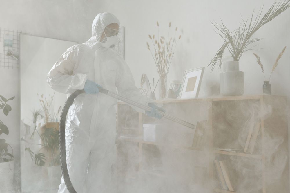 Technician fogging a living room with professional disinfection equipment in Oklahoma