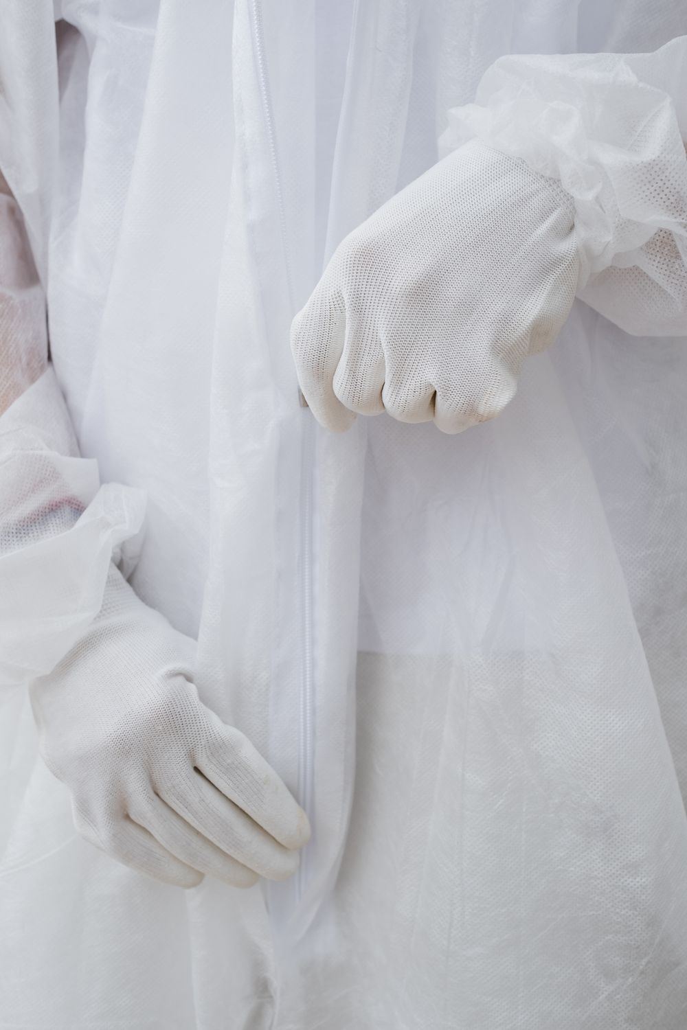 Close-up of a technician wearing protective gloves and a biohazard suit in Skiatook, Oklahoma