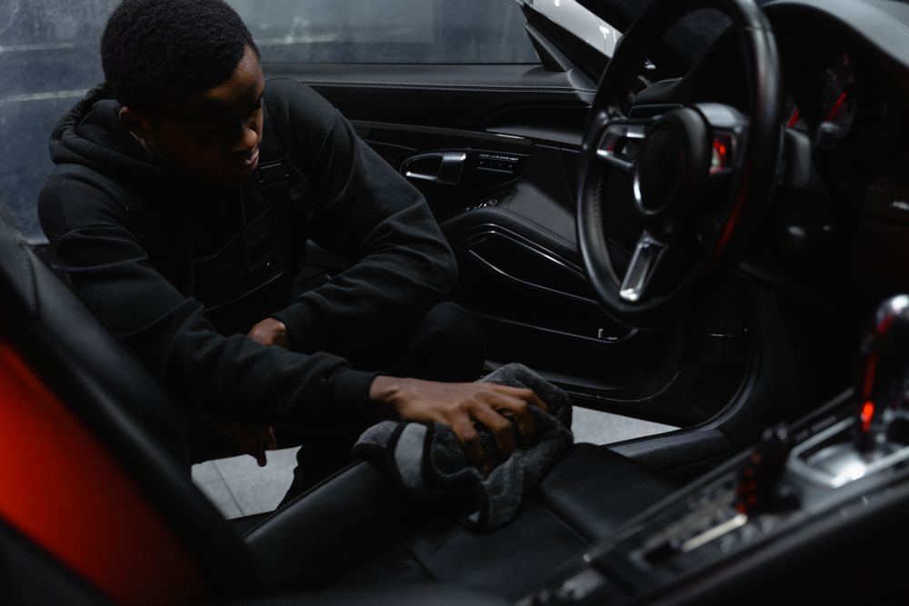 Technician detailing a car interior during professional vehicle cleanup in Oklahoma